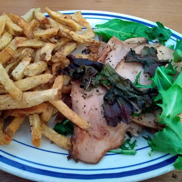 Turkey pastrami on greens and fries.