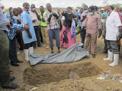 Officials surround Kwekwe Mwandaza's body after it was exhumed in Kinango, Kwale county on September 12, last year. PHOTO/ANDREW KASUKU.