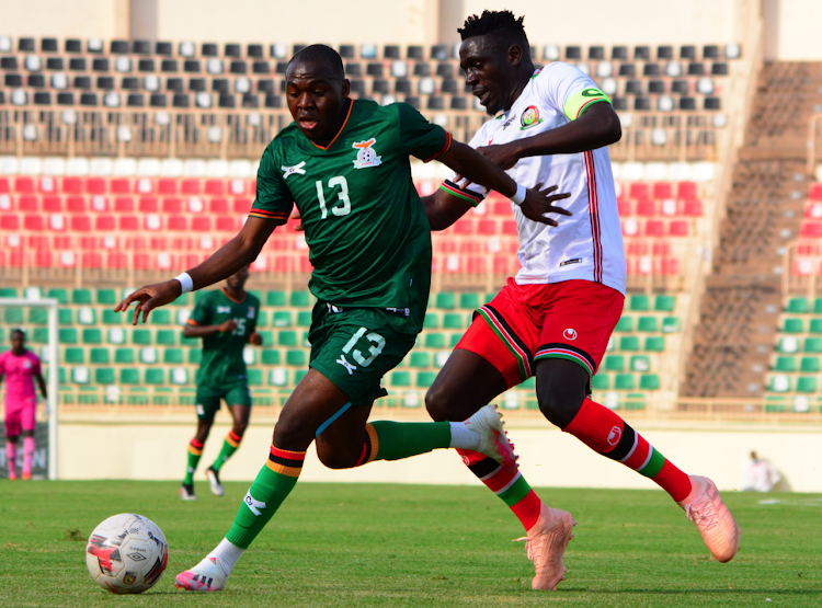 Zambia's Godfrey Nawenya (L) contests for the ball with Brian Mandela of Harambee Stars during their International friendly match at Nyayo Stadium.