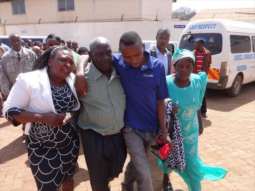 James Wachira (Second Left) is taken to safety by his relatives after he was roughed up by Teresia Wambui’s family /JOHN KAMAU