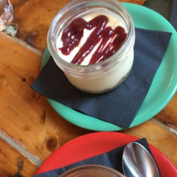 Foreground creme de pots (chocolate under the caramel topping); background cheesecake with strawberry jam