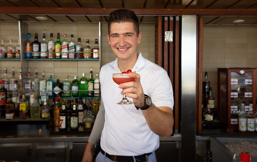 Marko-with-mary-pickford.jpg - A mixologist shows off a Mary Pickford cocktail at the Sunset Bar on Celebrity Equinox. 