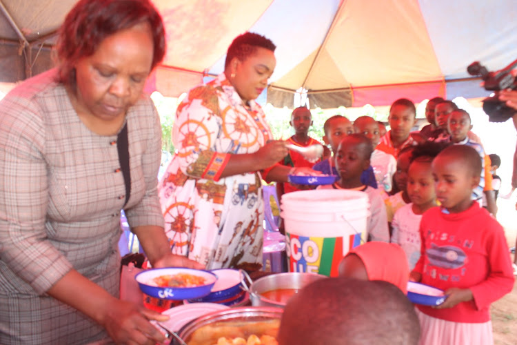 Machakos subcounty police commander Rhoda Kanyi feeding children at Mwiso Children Rescue Centre in Mwala on Saturday, December 25.