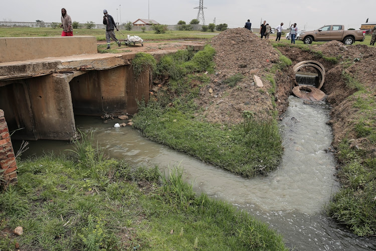 Raw sewage (right) merges with a clean water source near Sharpeville, south of Johannesburg.