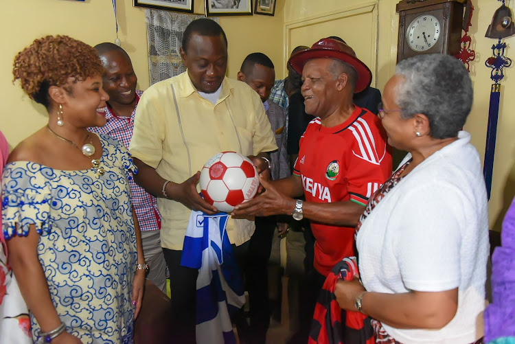 President Uhuru Kenyatta and First Lady Margaret Kenyatta receive a ball from football legend Joe Kadenge when they visited him at his residence in South B, Nairobi