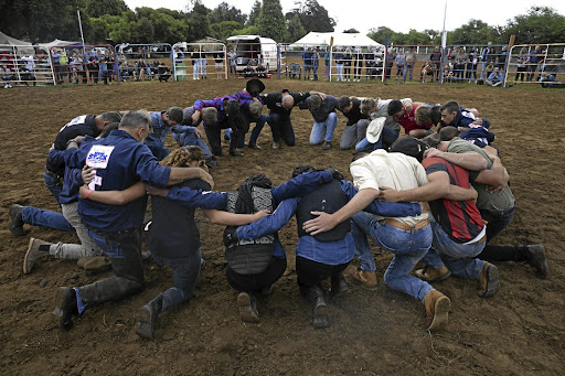 A prayer circle before the bull ride.