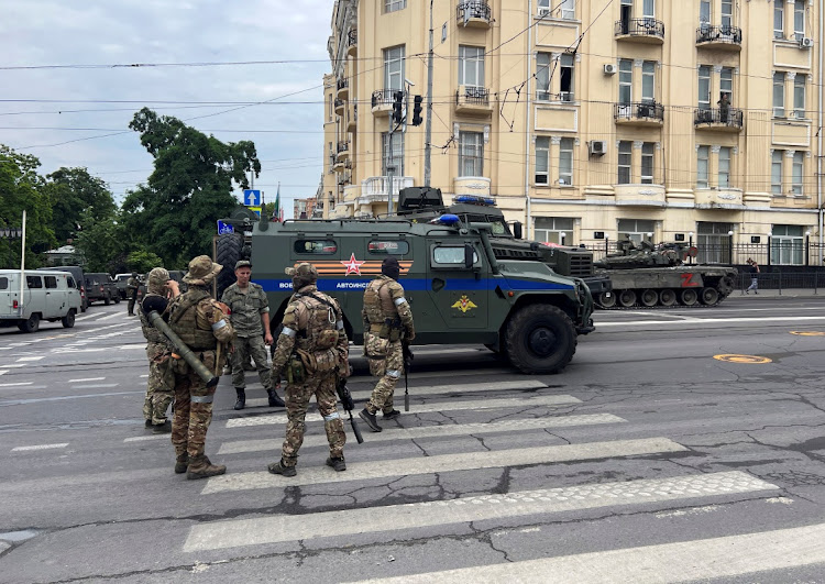 Fighters of Wagner private mercenary group speak with a Russian service member in a street near the headquarters of the Southern Military District in the city of Rostov-on-Don, Russia, June 24, 2023.