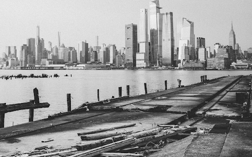 Grayscale Photo of Body of Water Near City Buildings Preview 1