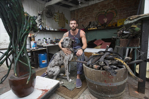 Janko de Beer with his dog, Sheena, in the studio where he weaves seaweed into sculptures