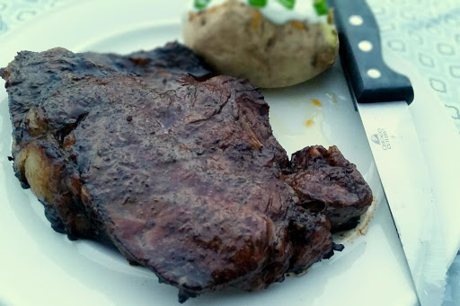 Marinated grilled ribeye with baked potato side. 