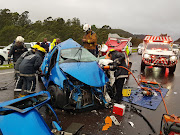 Paramedics and firefighters attend to the scene of an accident on the N3 near Shongweni in which five people were killed. 