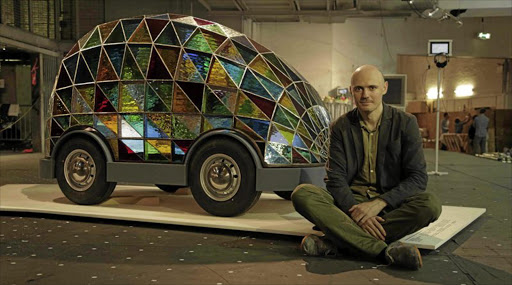 Dominic Wilcox with his stained-glass driverless car.