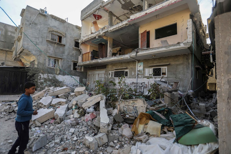 Palestinians inspect the damage to their homes caused by Israeli airstrikes on December 20 2023 in Khan Yunis, Gaza.