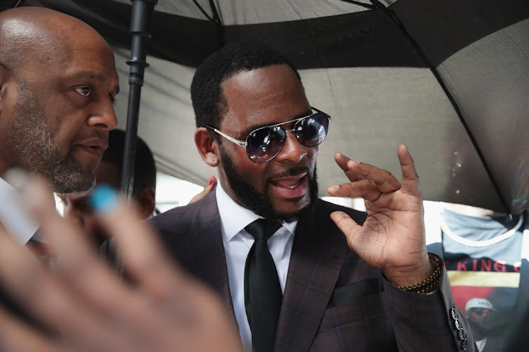 R&B singer R. Kelly (R) leaves the Leighton Criminal Courts Building following a hearing on June 26, 2019 in Chicago, Illinois.