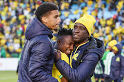 Mamelodi Sundowns striker Cassius Mailula is consoled by defender Rushine de Reuck and coach David Notoane after they were eliminated in the Champions League by Wydad Athletic Club at Loftus Stadium.