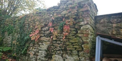 Cracks down the corner of a mortared limestone wall