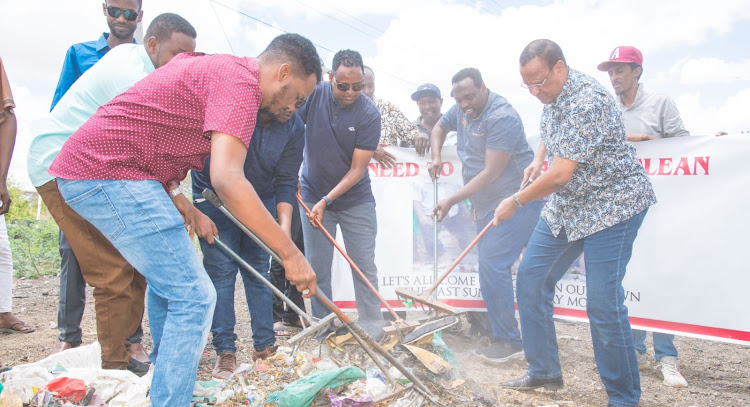 Garissa Governor Nathif Jama (right), county leaders and residents collect garbage along Ngamia road on Tuesday, September 27, 2022