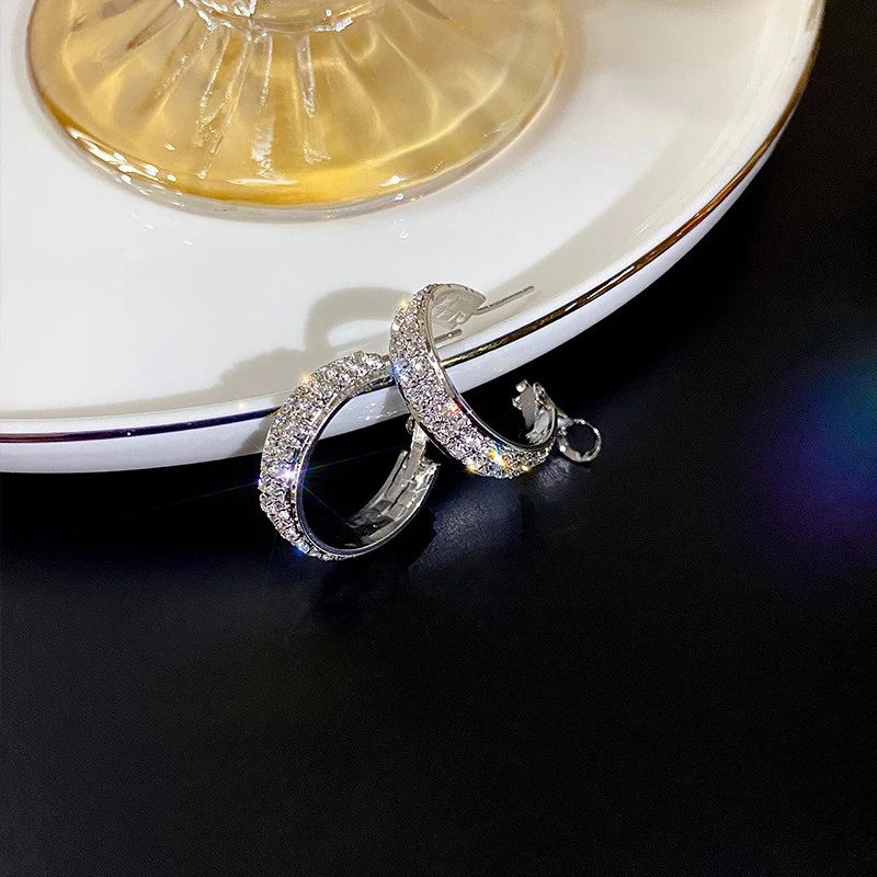 Boucles d'oreilles femme tendance argentées, micro-serties de diamants, pour un look sophistiqué et étincelant.