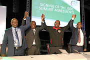 Sipho Pityana, President Cyril Ramaphosa, Bheki Ntshalintshali and Thulani Tshefuta celebrate after  signing a framework agreement to create 275 000 jobs.