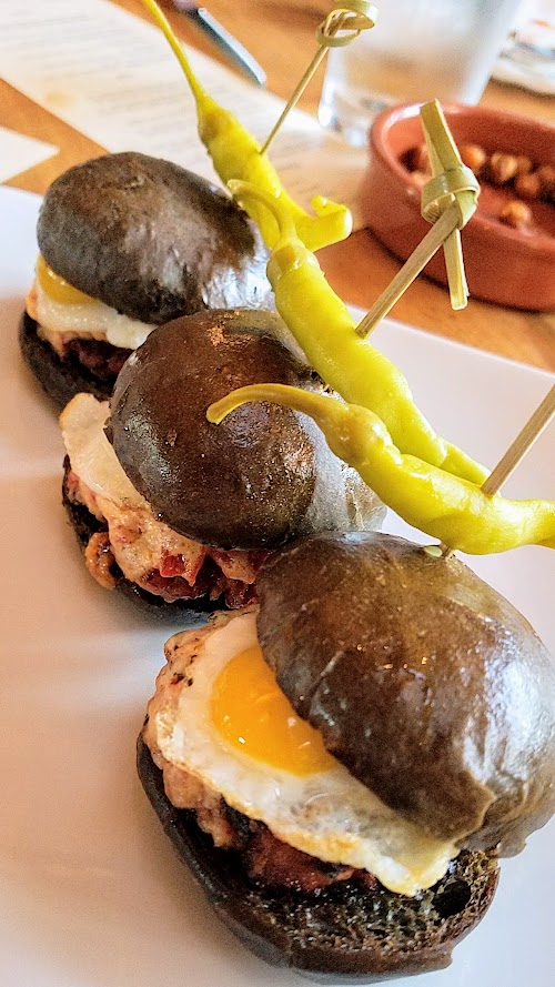 Pinxtos at Urdaneta:Txistorra slider with house chorizo sausage, cabra pimento cheese, kalimoxto ketchup, quail egg, squid ink brioche bun