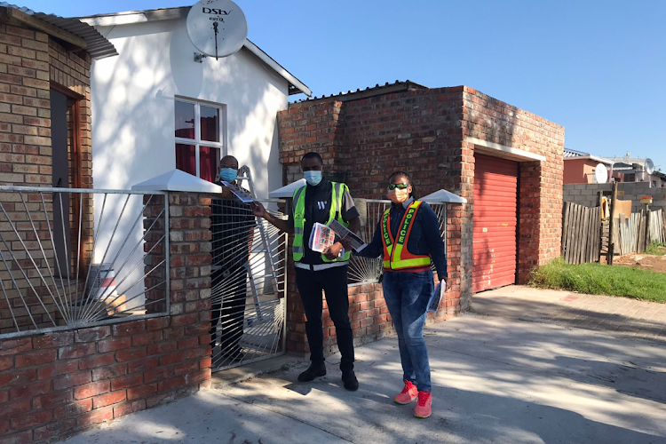 Police officers hand over pamphlets during an anti-gender-based violence campaign in Gqeberha