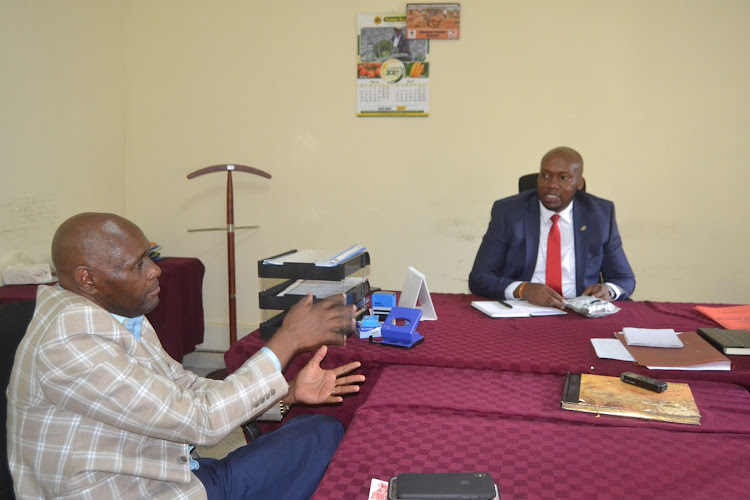 Euticauls Wambua explains a point to Kitui Agriculture CEC Stephen Kimwele