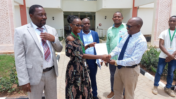 Adolescent advocacychampion Gladys Kangombe hands over a memorandum to county assembly budget committe chair Manza Beja and Health Commitee Vice Chair Tumaini Mwachaunga at Kwale assembly in Matuga sub-county on Thursday, March 14, 2024.