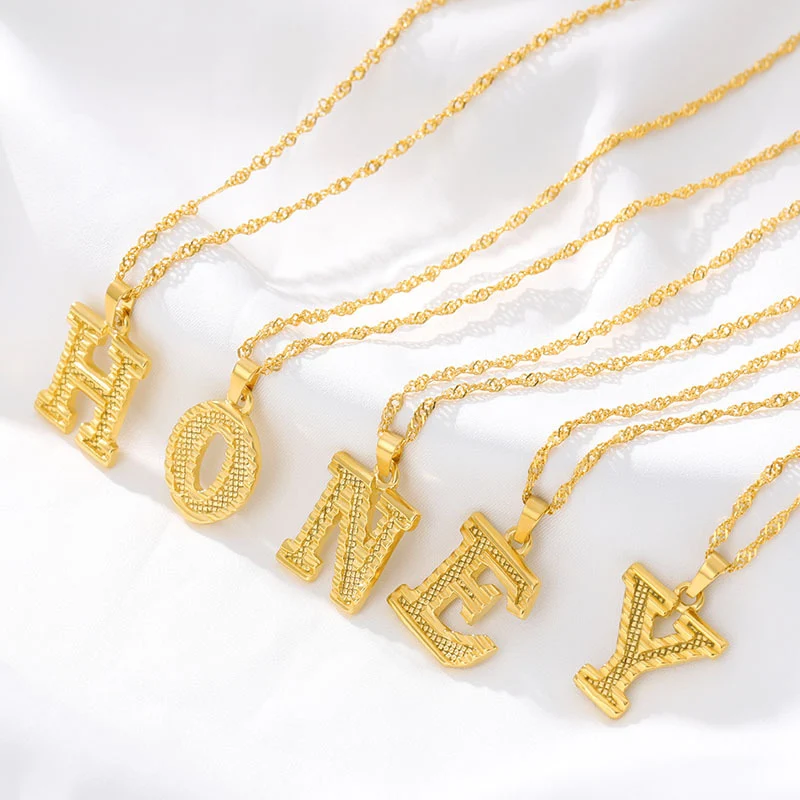 Title 2, Collier avec pendentif plaqué or 26 lettres. Un...