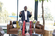 Pitso Mosimane parades the three trophies he won with Mamelodi Sundowns during the past season. 