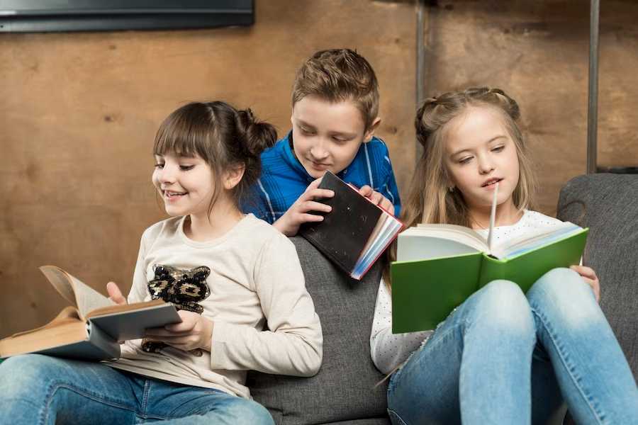 Three children engaged in reading