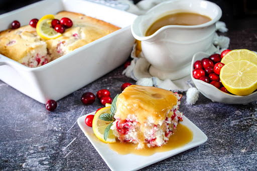 A slice of Ellie's Cranberry Cake With Lemon Butter Sauce on a plate.