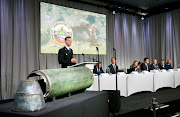 Dutch police officer Wilbert Paulissen, head of the National Crime Squad, is pictured next to a damaged missile as he presents interim results in the ongoing investigation of the 2014 MH17 crash that killed 298 people. 