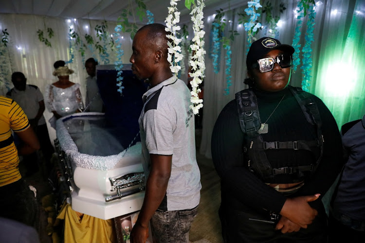 Enobong Udofia, 26, a member of the female-only security team Dragon Squad Limited, stands guard at a funeral event in Etinan, Akwa Ibom, Nigeria, November 19, 2022.