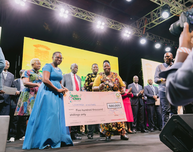 Beryl Achieng of Ngomongo Ministers (SDA Church Ngomongo South) receives a cheque from deputy director of Culture and Arts Stellah Kemunto.