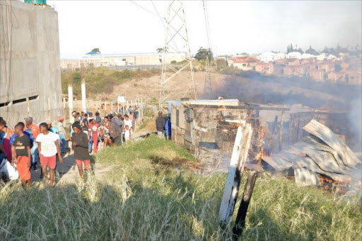 DISASTER STRIKES: Residents of Nompumelelo flee a fire that destroyed several shacks yesterday afternoon Picture: INGANATHI WILLIAMS