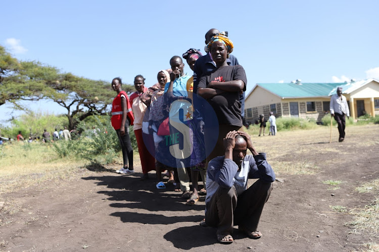 Residents look on during food distribution exercise by Red Cross at Burat, outskirts of Isiolo town on January 13, 2023