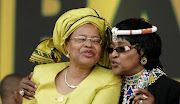  Graca Macel and Winnie Madikizela Mandela embrace each other.