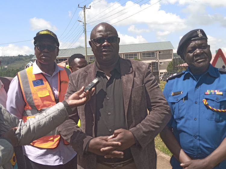 Bomet Central Deputy Subcounty Commissioner Victor Kisachi (centre) with NTSA regional coordinator Patrick Tilitei (left) and Bomet County Traffic Enforcement Officer Ogolla(right) adress journlists after a tree planting session at Bomet University College on May 15, 2024