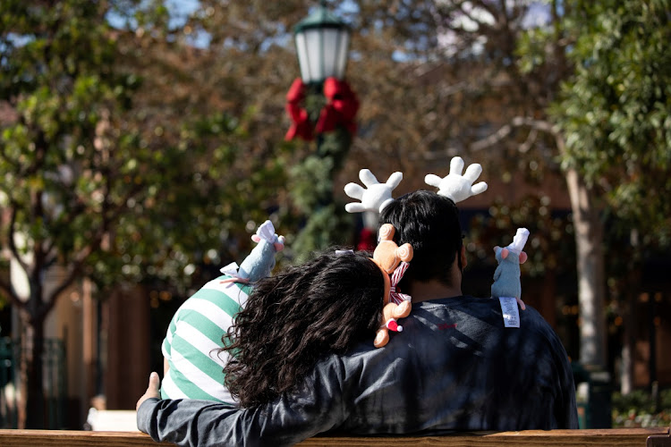 A couple sits on a bench inside Disney California Adventure as its retail stores and restaurants partially reopened without rides during the outbreak of Covid-19, in Anaheim, California, US, on November 19, 2020.