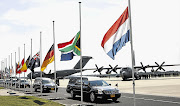 TRIBUTE: Hearses bearing the remains of victims of Malaysia Airlines flight MH17, downed over rebel-held territory in eastern Ukraine last week, pass flags flown at half-mast at Eindhoven Airport in the Netherlands en route to a military base in Hilversum Picture: REUTERS