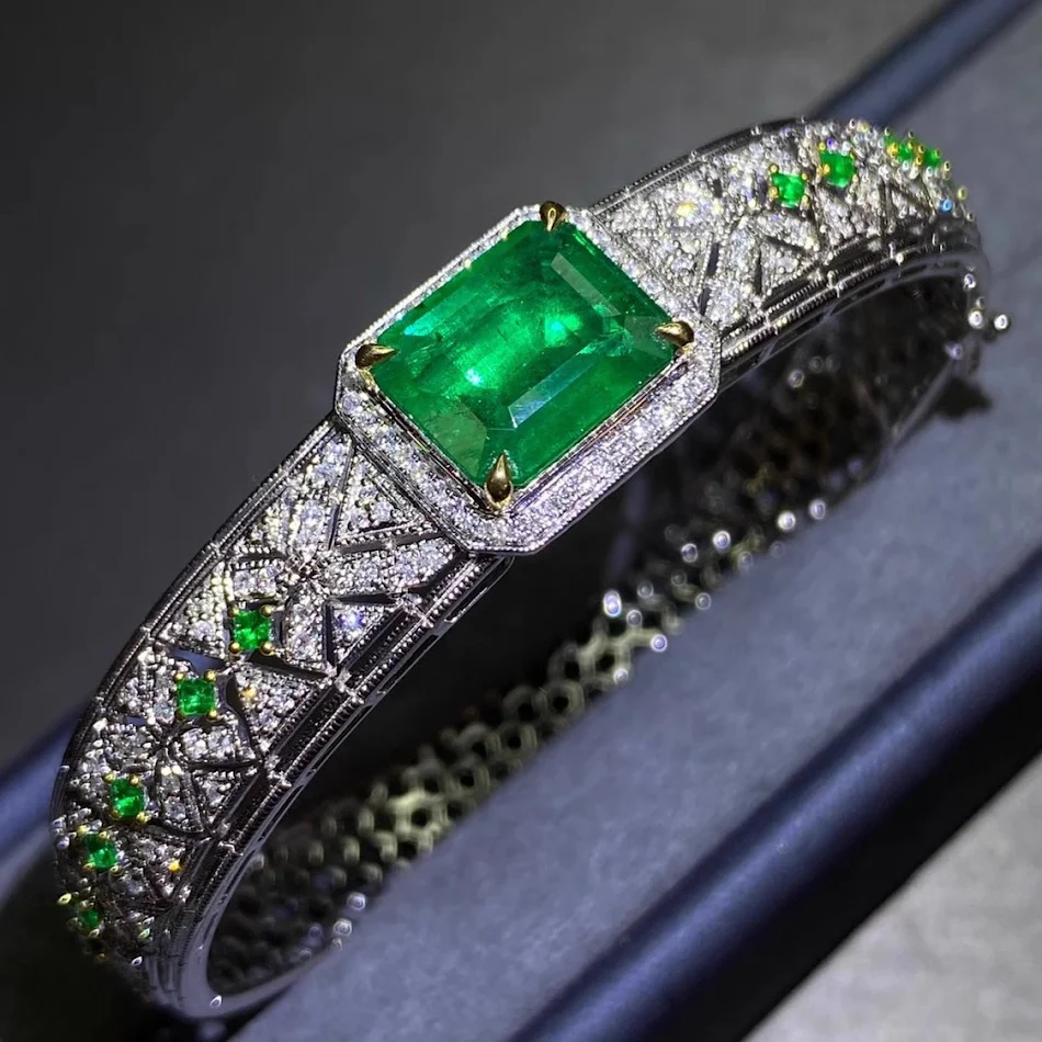 Tweekleurige Armband met Micro-Ingelegde Diamanten en Smaragden Verfraai uw pols met deze elegante armband, een subtiele en verfijnde schittering voor elke look.