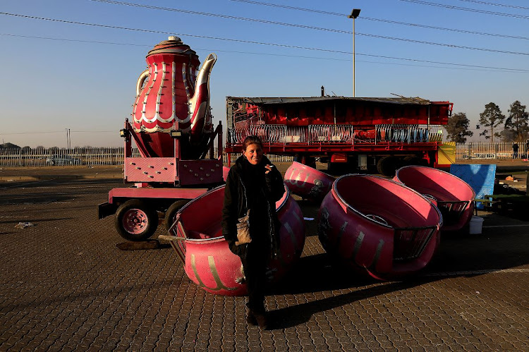 Louise Horn, manager of Tommy's World Fair, takes a break next to some of the fair's dismantled rides.