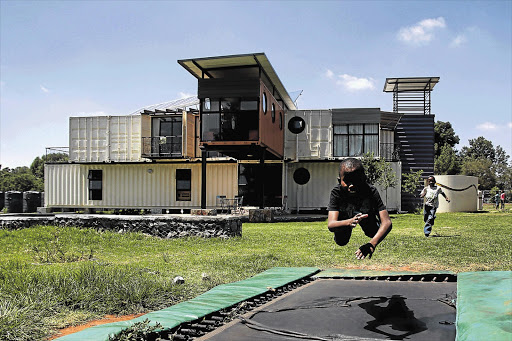 Children at play at the new eco-friendly New Jerusalem Children's Home, in Midrand, northern Johannesburg. The home is built of shipping containers, uses solar panels and recycles water for its garden.