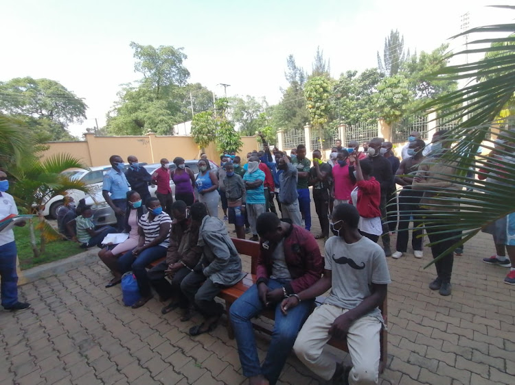 Some of the joggers charged before a Kisumu court for breaking social distancing rules stand behind other unrelated suspects on May 29, 2020.