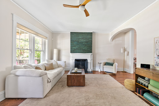 White living room with sofa, fireplace, fan in this luxury house for sale in Richmond ($725,000)