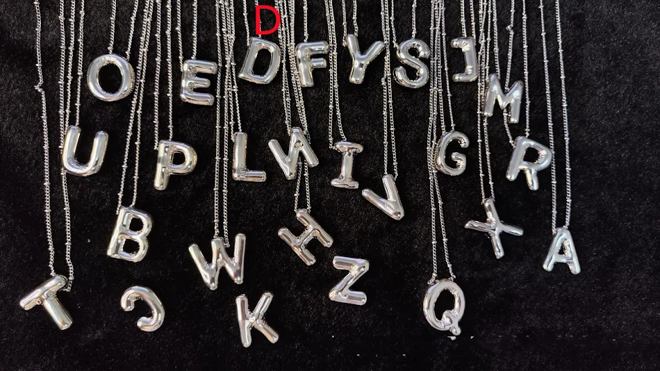 Collier avec pendentif lettres brillantes en cuivre. Ajoutez une touche élégante et personnalisée à votre look. Un accessoire parfait.