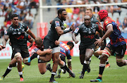 Lukhanyo Am of the Sharks tackled by Pieter Jansen (l) and Marvin Orie of the Lions (r) during 2019 SuperHero Sunday game between the Lions and Sharks at Cape Town Stadium on 3 February 2019.