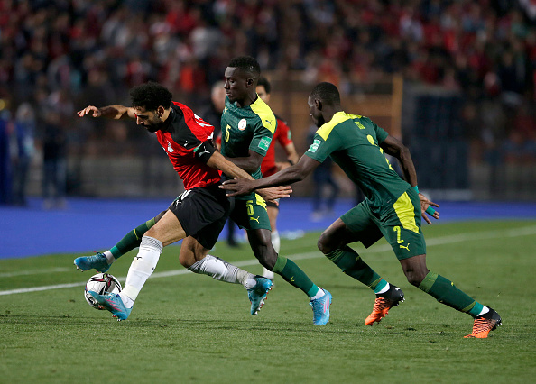 Mohamed Salah of Egypt is tackled by Idrissa Gueye and Saliou Ciss of Senegal during their FIFA World Cup Qatar 2022 qualification match at Cairo International Stadium on Friday.