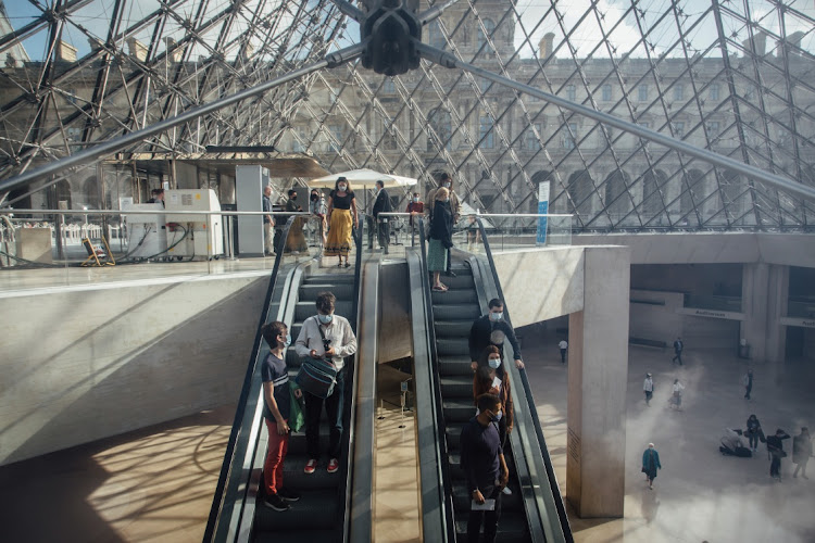 Visitors ride escalators in the Louvre Museum in Paris, France. Picture: BLOOMBERG/CYRIL MARCILHACY