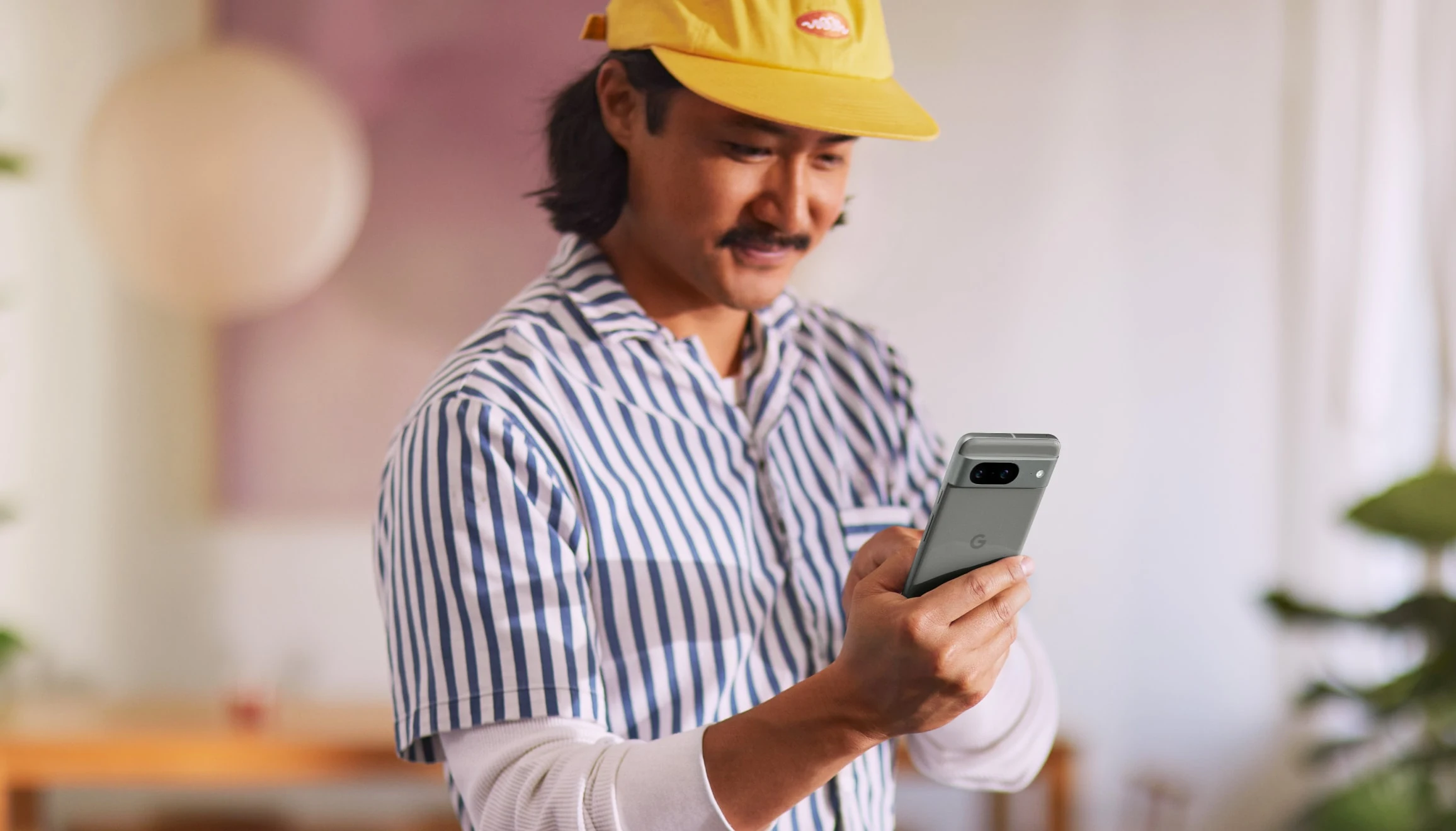 A person holds a Pixel 8 in Obsidian color.